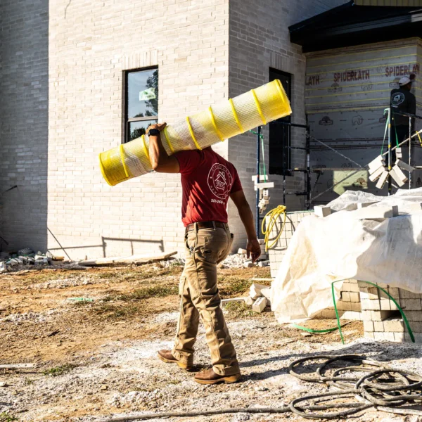 a man carrying a yellow tube on his head