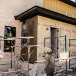 a man painting a wall of a house