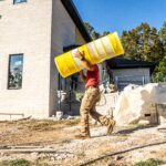 man carrying roll of spiderlath